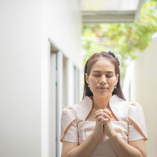 Person meditating peacefully outdoors with a serene natural background.